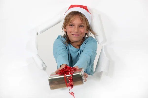 Klein meisje in santa hat aanbod aanwezig — Stockfoto