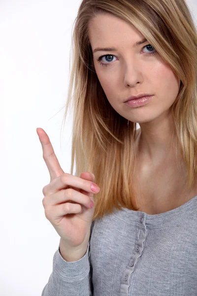 Vrouwelijke model met haar vinger omhoog. — Stockfoto