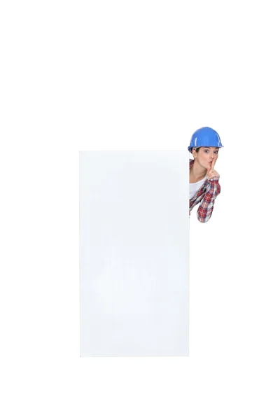 Жінка-будівниця стоїть на плакаті стискаючи — стокове фото