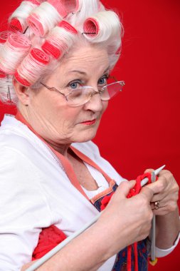 Old lady wearing hair rollers and knitting clipart