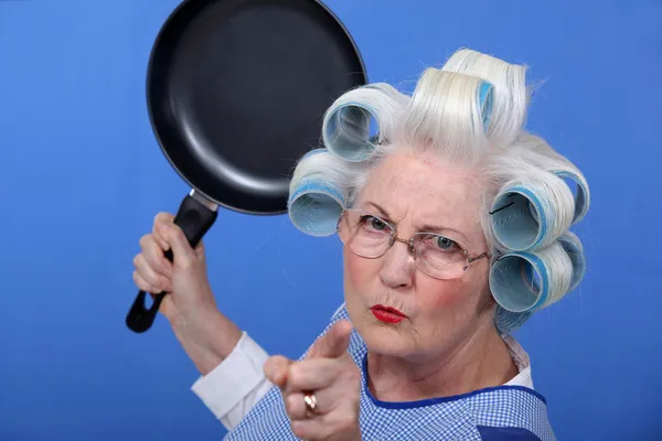 Angry old woman with a frying pan — Stock Photo, Image