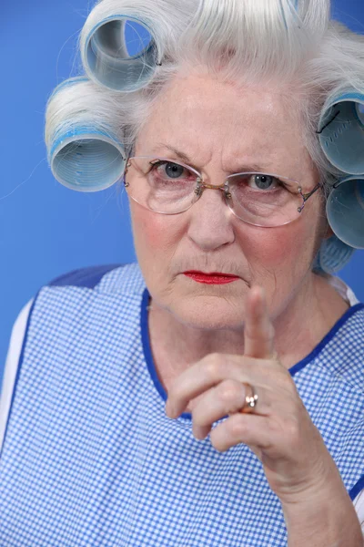 Θυμωμένη γυναίκα με τα μαλλιά της σε κυλίνδρους — Φωτογραφία Αρχείου