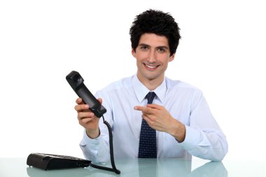 Cheerful employee pointing at telephone clipart