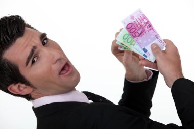 Happy businessman holding banknotes clipart