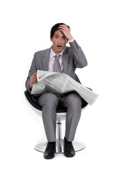 A businessman reading bad news. clipart