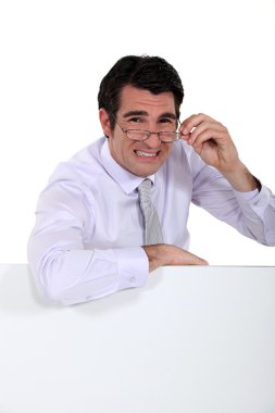Doubtful man peering over his glasses clipart