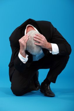 Businessman holding his head in despair clipart