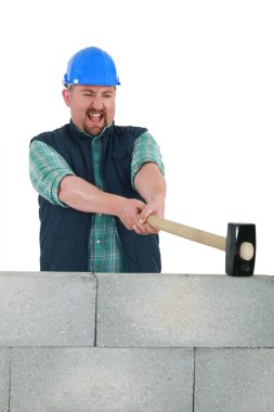 Man destroying wall with sledge-hammer clipart