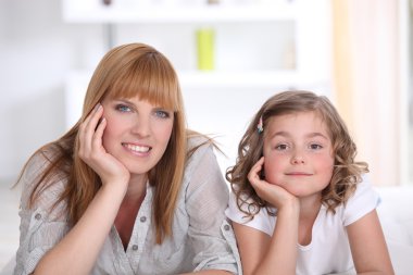 Mother and daughter relaxing at home clipart