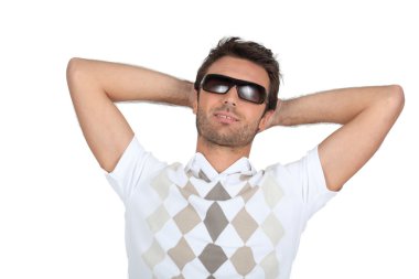 Man wearing sunglasses with his hands behind his neck clipart