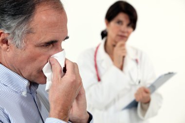 Man blowing his nose next to a doctor clipart