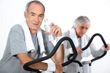 65 years old woman and man doing cardio training clipart