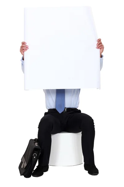 Muž seděl na stoličce drží prázdné plakát — Stock fotografie