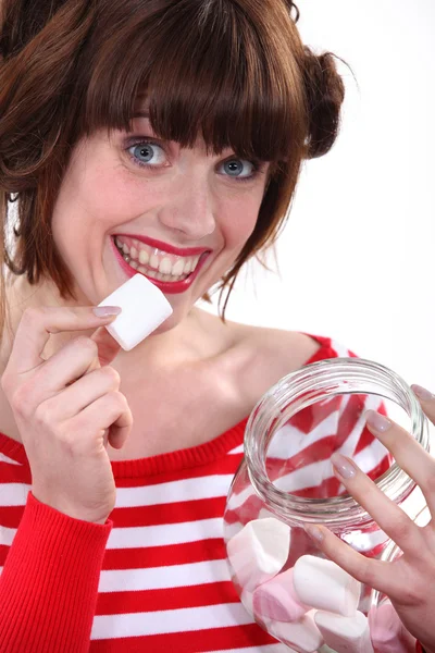 Mulher comendo marshmallows fora do frasco — Fotografia de Stock