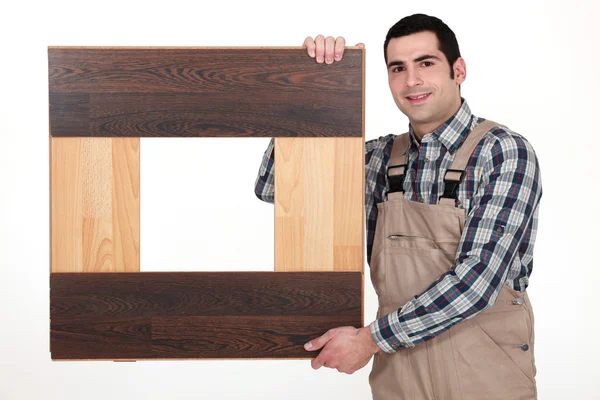 寄木細工の床のスラットを持つ男 — ストック写真
