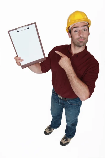 Byggnadsarbetare pekar på hans Urklipp. — Stockfoto