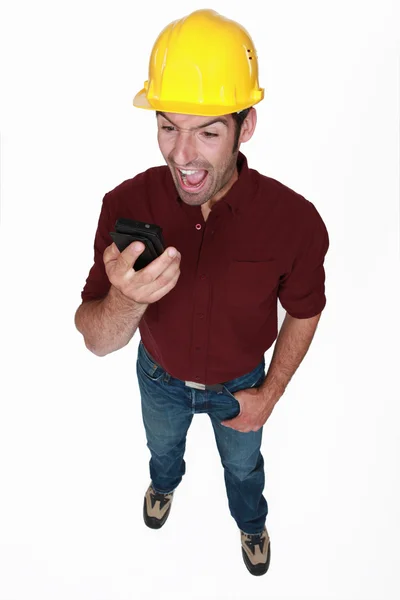 Angry builder shouting down mobile telephone — Stock Photo, Image