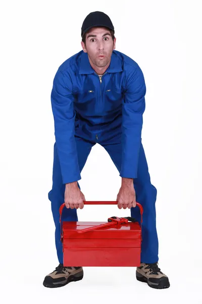 Hombre luchando para levantar caja de herramientas — Foto de Stock