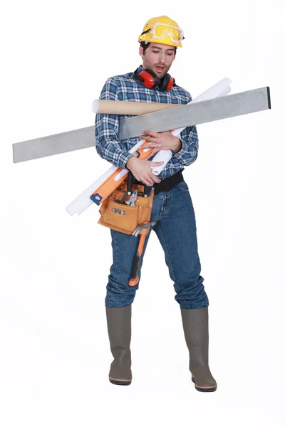 A construction worker with his arms loaded. — Stock Photo, Image