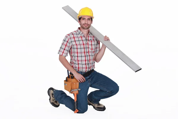 Porträt eines gutaussehenden Zimmermanns vor weißem Hintergrund, der Stahlpfosten trägt — Stockfoto