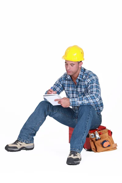 Trabajador de la construcción escribiendo en un cuaderno — Foto de Stock