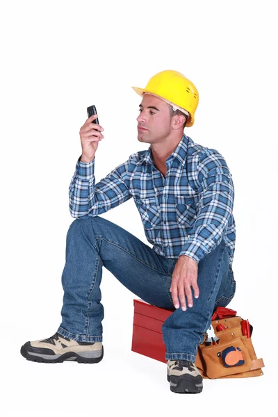 Homme assis sur la boîte à outils envoyer un message texte — Photo