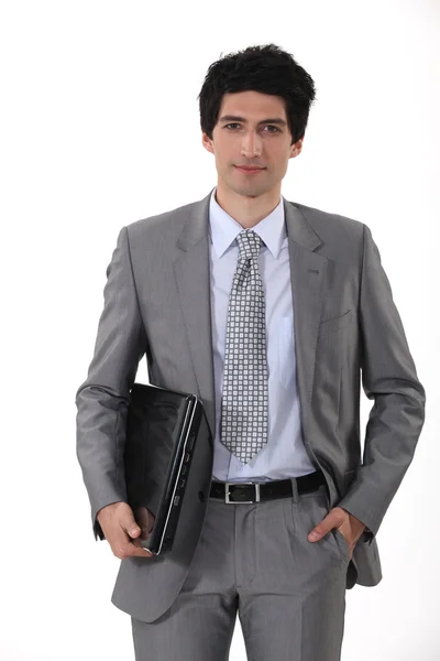 Smart businessman carrying laptop — Stock Photo, Image