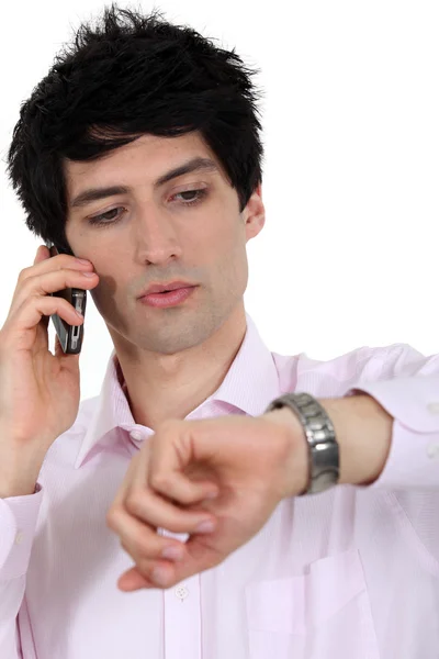 Ένας επιχειρηματίας από το τηλέφωνο, κοιτάζοντας το ρολόι του. — Φωτογραφία Αρχείου