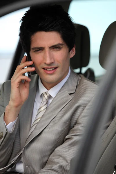 Businessman making call from parked car — Stock Photo, Image