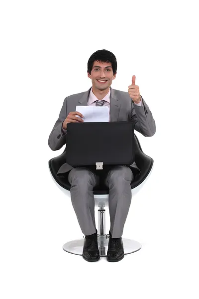 Сидячий молодий бізнесмен з великим пальцем вгору — стокове фото