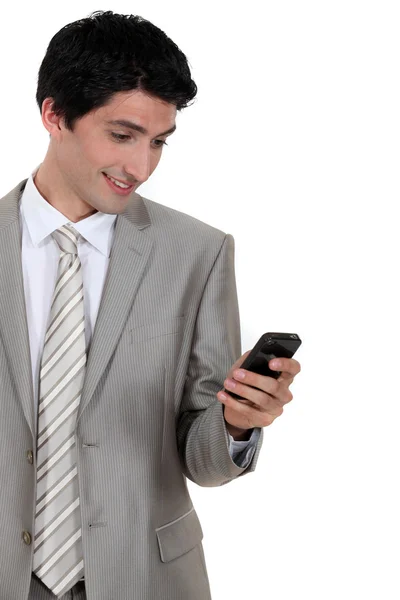 Empresário animado por mensagem de texto no celular — Fotografia de Stock