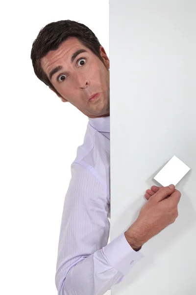 Puzzled man stood with blank advertising board — Stock Photo, Image