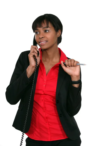 Employé de bureau tenant un stylo pendant un appel téléphonique — Photo