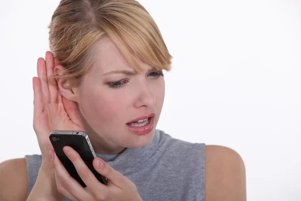 Mujer tratando de escuchar a una persona en su teléfono celular —  Fotos de Stock