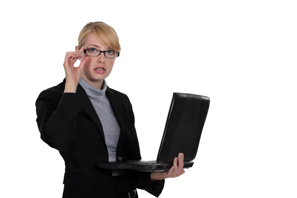 Młoda kobieta okularach działa na laptopie na białym tle — Zdjęcie stockowe