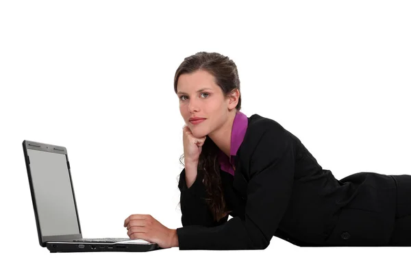 Affärskvinna liggande med en bärbar dator — Stockfoto