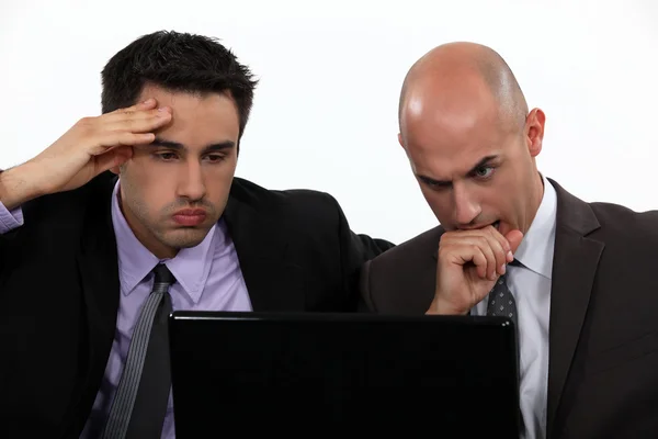 Стрессовые бизнесмены смотрят на экран ноутбука — стоковое фото