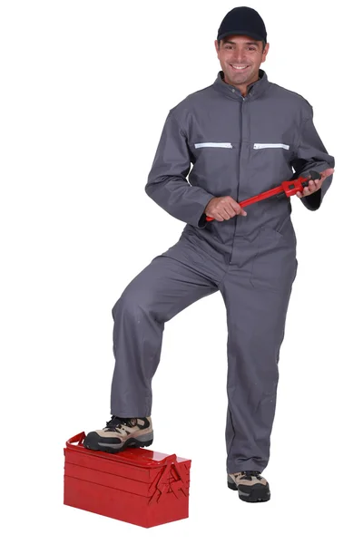 Tradesman with his foot propped on a toolbox — Stock Photo, Image