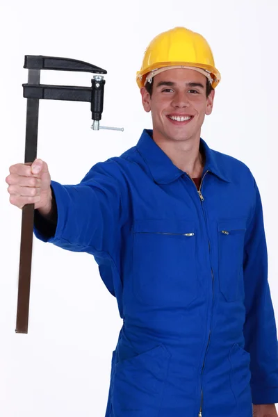 Jonge bouwvakker met een f-klem — Stockfoto