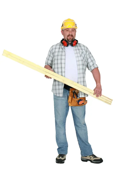 Tradesman carrying a plank of wood — Stock Photo, Image