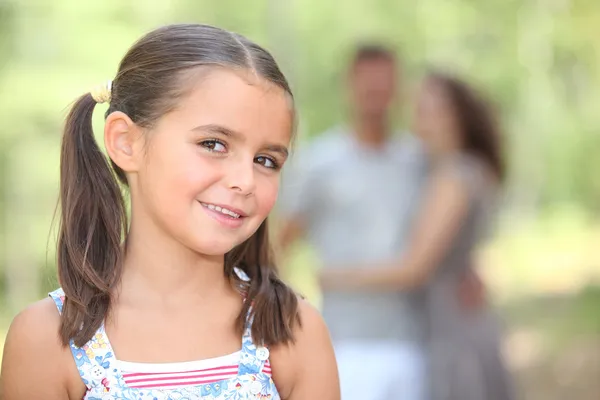 Маленькая девочка в парке с родителями — стоковое фото