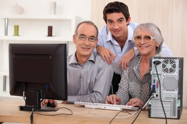 Nieto och farföräldrar med dator — Stockfoto