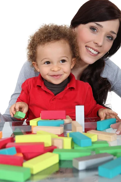 Мама сидела с сыном, играя в строительные блоки — стоковое фото