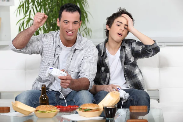 Father and son playing video games together — Stock Photo, Image