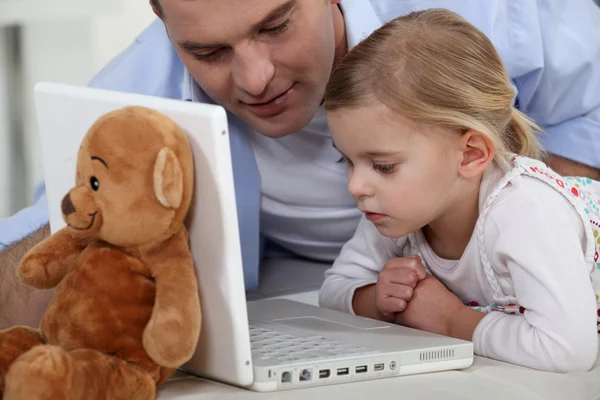 Menina e seu pai usando o laptop — Fotografia de Stock
