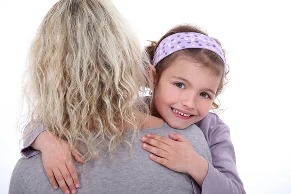 Jong meisje haar moeder knuffelen — Stockfoto