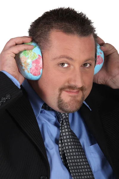 Man die betrekking hebben op zijn oren met globe — Stockfoto