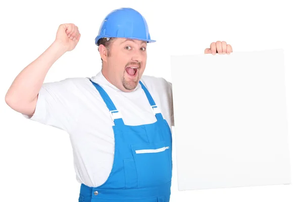 A cheerful tradesman holding up a blank sign — Stock Photo, Image