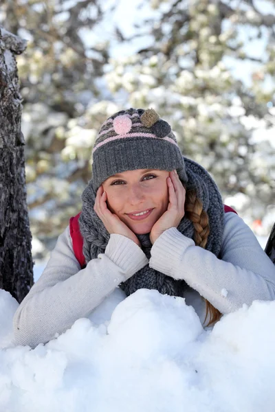 Blonde Frau liegt im Schnee — Stockfoto
