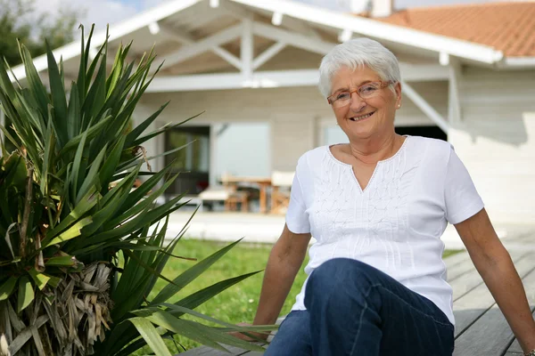 Old woman in her front garden — Stock Photo, Image